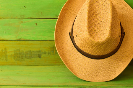 Brown cowboy hat on green wooden texture backgroundの写真素材