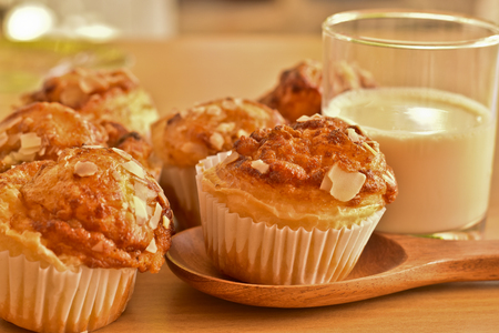 Delicious homemade almond muffins and a glass of milk on wooden table. Healthy food concept.の写真素材