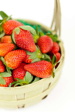 Fresh strawberries in a basket on a white background の写真素材
