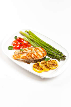 Grilled salmon steak with asparagus and cherry tomatoes の写真素材