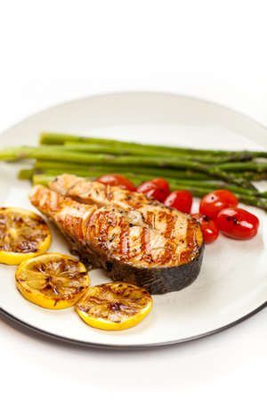 Grilled salmon steak with asparagus and cherry tomatoesの写真素材