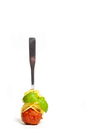 Meatball with spaghetti and basil on a forkの写真素材