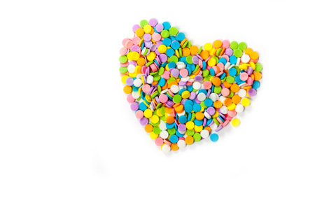 Colorful candy sprinkles heart shape isolated on white background