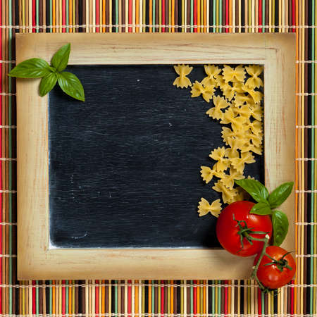 Italian Food. Pasta, Tomatoes, Basil on black chalkboardの写真素材