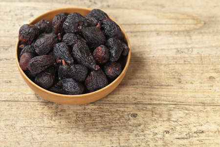 Black dried figs on a wooden surfaceの写真素材