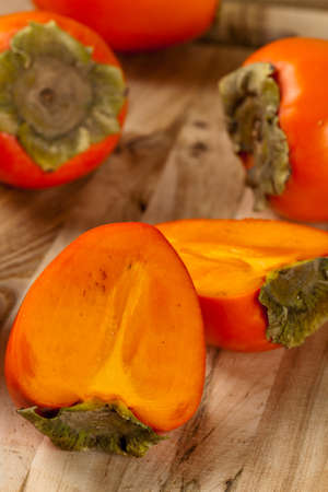 Fresh ripe persimmon on a wooden table. Selective focus.の写真素材