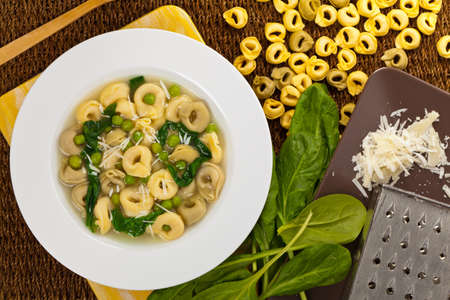 Italian Tortellini Pasta Soup with Peas and Spinach. Selective focus.の写真素材