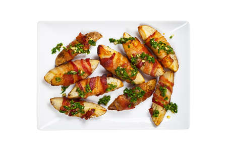 Bacon Wrapped Potatoes Wedges with Parsley Garlic Pesto Sauce Isolated on Whiteの写真素材
