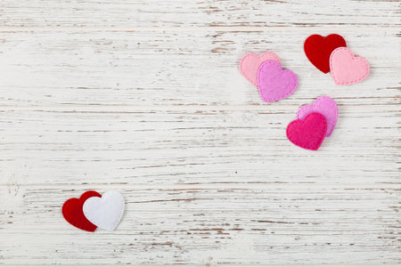 Valentines Day Background Card with Fabric Hearts over Wooden Background. Selective focus.