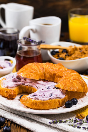 Continental Breakfast with Croissants and Blueberry Cream Cheese Spread. Selective focus.