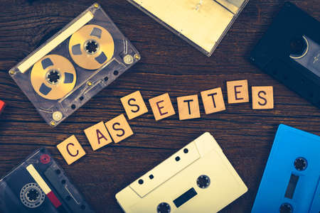 Compact Audio Cassette Tape on Wooden Background with Copy Space. Photo in retro style. Toned image.の写真素材