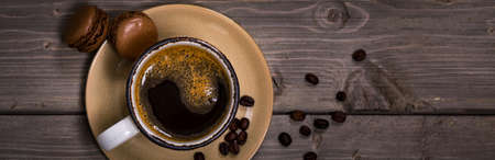 Dark Chocolate Macaron with Coffee Beans on Wooden Table. Selective focus.の写真素材