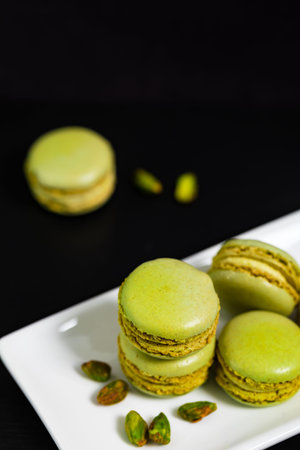 Green Pistachio Macaron Cookies on Black Background. Selective focus.