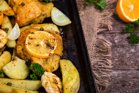 Chicken Thighs Roasted with Meyer Lemon and Potatoes. Selective focus.の写真素材