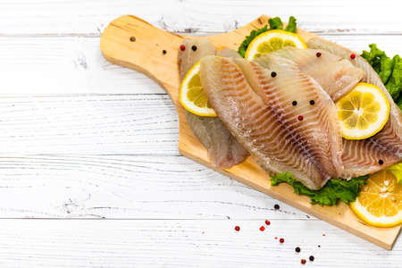 Whitefish Tilapia Fish Raw Fillet on White Wooden Background. Selective focus.の写真素材