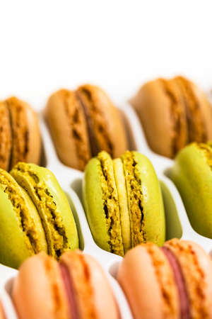 Colorful Macaroons Chocolate, Pistachio, Cherry, Orange, Vanilla Flavor Background. Selective focus.の写真素材