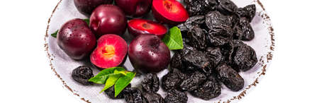 Fresh Plums and Dried Pitted Prunes Isolated on a white background. Selective focus.の写真素材