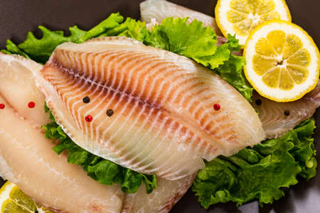 Whitefish Tilapia Fish Raw Fillet on Wooden Background. Selective focus.の写真素材