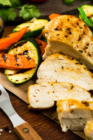 Grilled Chicken Breasts with Grilled Vegetables Zucchini and Carrot Background. Selective focus.の写真素材