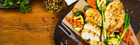 Grilled Chicken Breasts with Grilled Vegetables Zucchini and Carrot Background. Selective focus.の写真素材