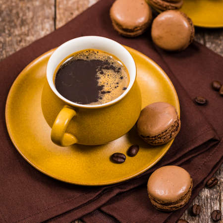 Dark Chocolate Macaron with Coffee Beans on Wooden Table. Selective focus.の写真素材