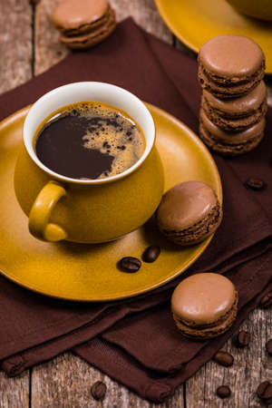 Dark Chocolate Macaron with Coffee Beans on Wooden Table. Selective focus.の写真素材