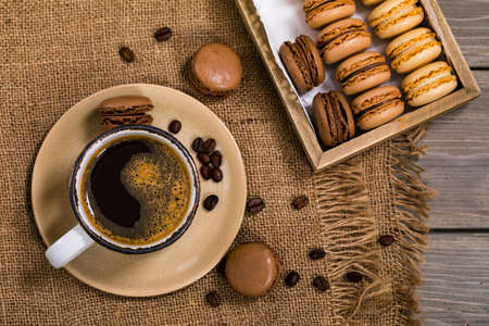French Chocolate Macarons with Coffee Beans on Wooden Table. Selective focus.の写真素材