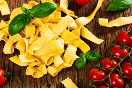 Ribbon Pasta Noodles Uncooked on Wooden Background. Selective focus.の写真素材