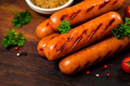 Grilled Smoked Hot Dogs Sausages on Wooden Background. Selective focus.の写真素材
