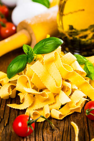Ribbon Pasta Noodles Uncooked on Wooden Background. Selective focus.の写真素材