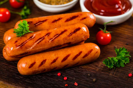 Grilled Sausages on Fork on Wooden Background. Selective focus.の写真素材