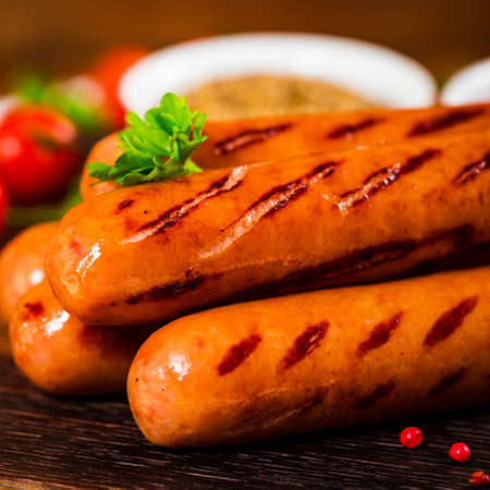 Grilled Sausages on Fork on Wooden Background. Selective focus.の写真素材