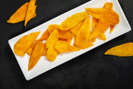 Dried Mango Fruit on Black Background. Selective focus.の写真素材
