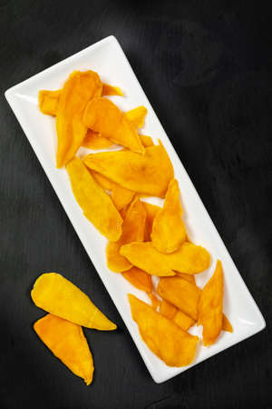 Dried Mango Fruit on Black Background. Selective focus.の写真素材