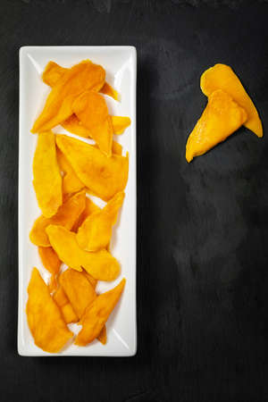 Dried Mango Fruit on Black Background. Selective focus.の写真素材