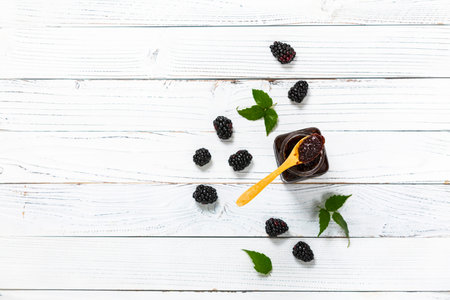 Jar of Blackberry Jam Preserves on White Wooden Background Top View. Selective focus.