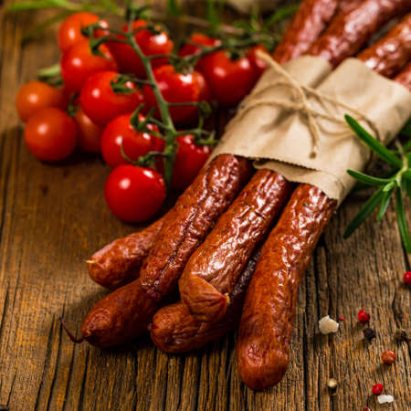Kabanos or Cabanossi Thin Dry Smoked Polish Sausage on Wooden Background. Selective focus.の写真素材