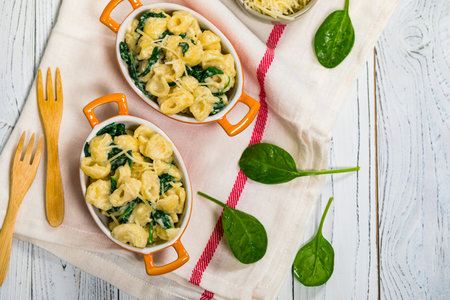 Parmesan Spinach Mac and Cheese on White Wooden Background. Selective focus.