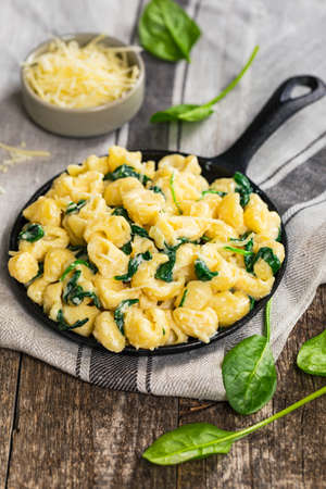 Parmesan Spinach Macaroni and Cheese on Wooden Background. Selective focus.の写真素材