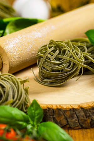 Spinach and Basil Pasta Nests on Wooden Background. Selective focus.の写真素材