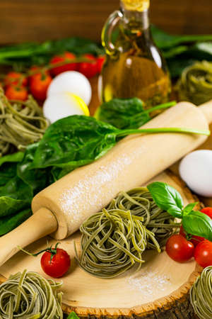 Spinach and Basil Pasta Nests on Wooden Background. Selective focus.の写真素材