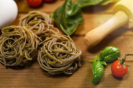 Spinach and Basil Pasta Nests on Wooden Background. Selective focus.の写真素材