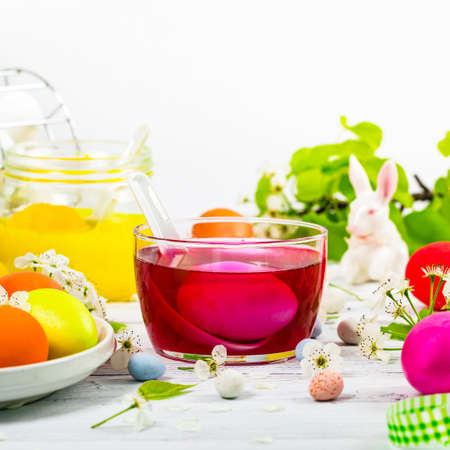 Easter Egg Dying Process. Preparing Decorative Easter Eggs, Bowls with Colored Paint with Eggs for painting. Selective focus.の写真素材