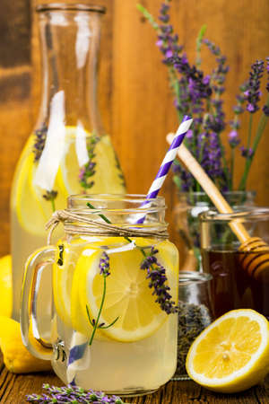 Lemonade with Lemons and Lavender. Cold Infused Detox Water with Lemon and Lavender. Provence Style. Selective focus.の写真素材