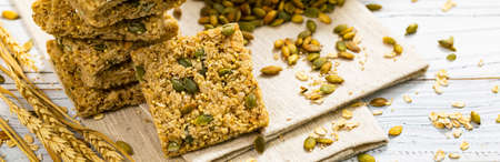 Multigrain Cereal Crunchy Squares Bars with Pumpkin Seeds on Wooden Background. Selective focus.の写真素材