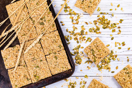 Multigrain Cereal Crunchy Squares Bars with Pumpkin Seeds on Wooden Background. Selective focus.の写真素材