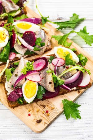 Beetroot and Pickled Marinated Herring Open Sandwich on Rye Bread. Selective focus.の写真素材