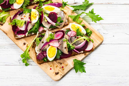 Beetroot and Pickled Marinated Herring Open Sandwich on Rye Bread. Selective focus.の写真素材