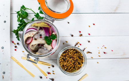 Pickled Marinated Herring with Spices, Radish and Red Onion on Wooden Background. Selective focus.の写真素材