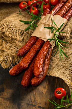 Kabanos or Cabanossi Thin Dry Smoked Polish Sausage on Wooden Background. Selective focus.の写真素材